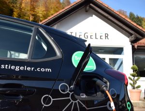 Stiegeler Elektro-Firmenauto zum Laden angeschlossen vor Niederlassung Schönau