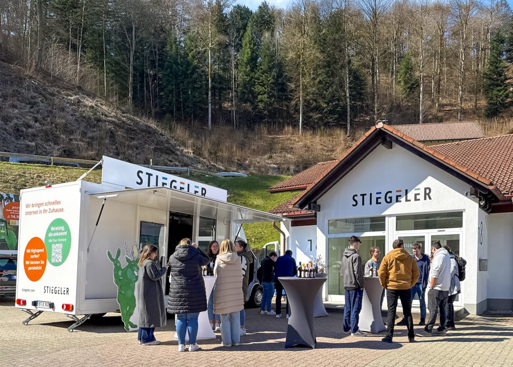Das Stiegeler-Team nimmt das Stiegeler Infomobil für die Saison 2026 vor der Niederlassung in Schönau in Empfang.