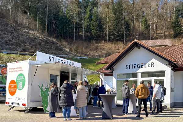 Das Stiegeler-Team nimmt das Stiegeler Infomobil für die Saison 2026 vor der Niederlassung in Schönau in Empfang.