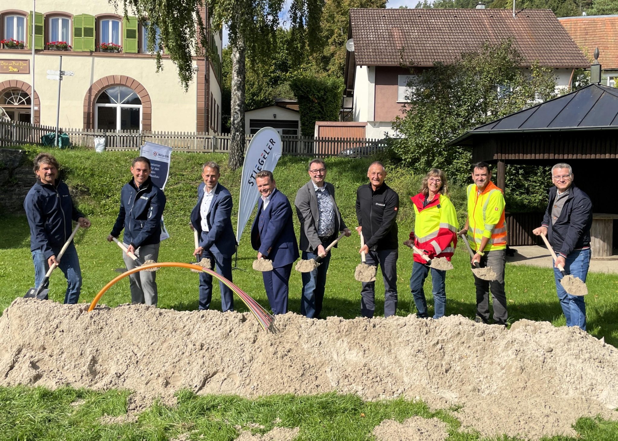 Vertreter der Netze BW, Stiegeler Geschäftsführer Alexander Siebnich, Bürgermeister Ralph Zimmermann, Ortsvorsteher Theo Walz, Stiegeler Vertriebsleiter Uwe Fries, Monika Mitzkat von den Stadtwerken Horb und Vertreter der Baufirma Turom beim Spatenstich zur Eröffnung des Strom- und Glasfaserausbaus in Horb-Dettlingen.