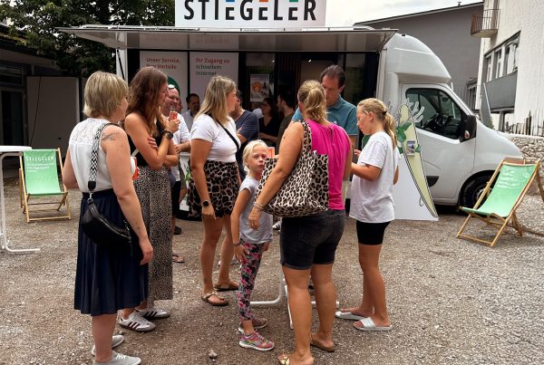 Eine Gruppe Menschen unterhält sich vor dem Stiegeler Info-Mobil beim Grillfest zum Abschluss des Glasfaserausbaus in Dogern.