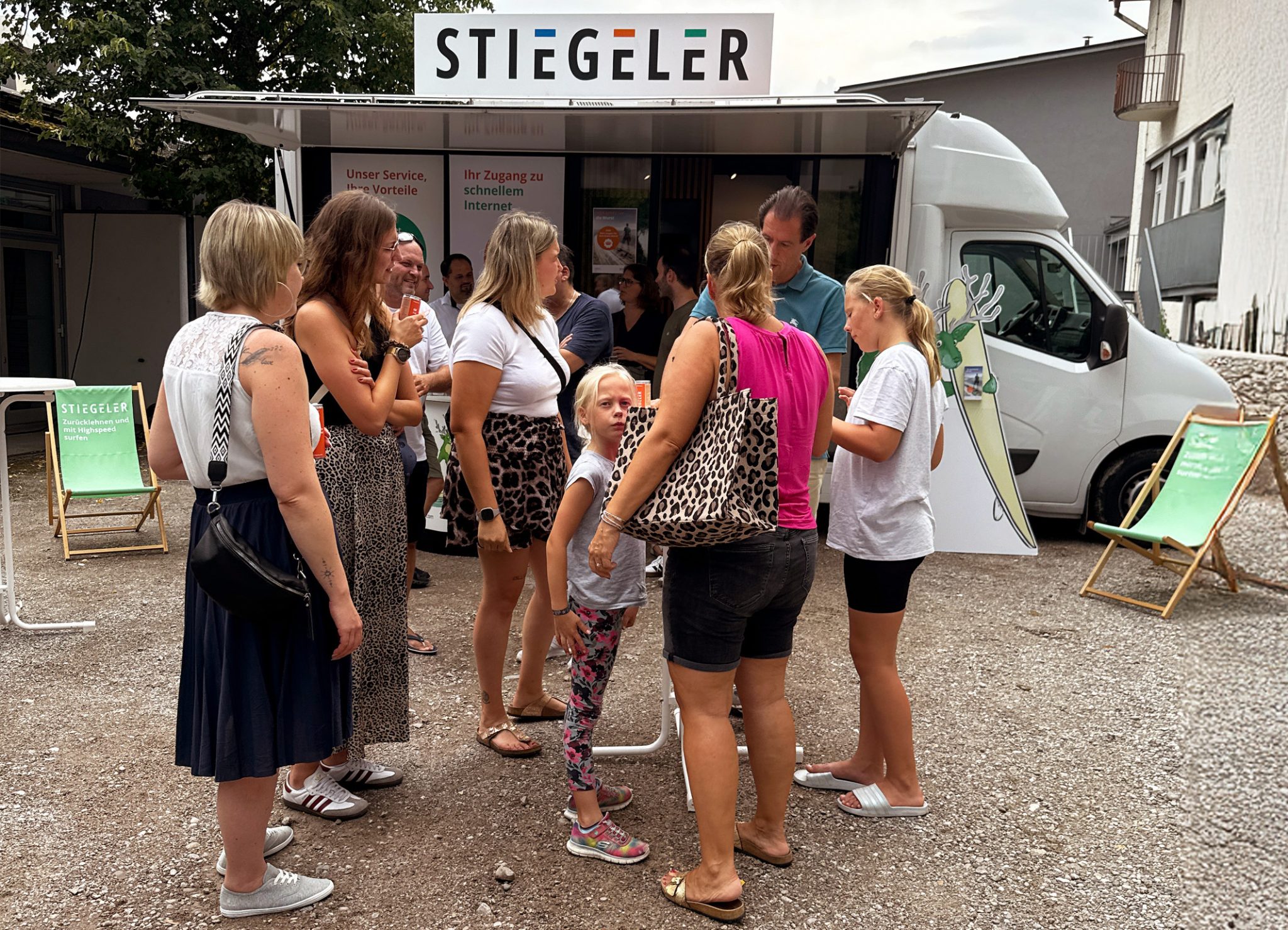 Eine Gruppe Menschen unterhält sich vor dem Stiegeler Info-Mobil beim Grillfest zum Abschluss des Glasfaserausbaus in Dogern.