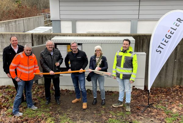 Vertreter der Gemeinde, der ausführenden Tiefbaufirma und das Stiegeler-Netzbauteam vor dem Verteiler in Häusern, von dem aus die Kunden mit Glasfaser versorgt werden.