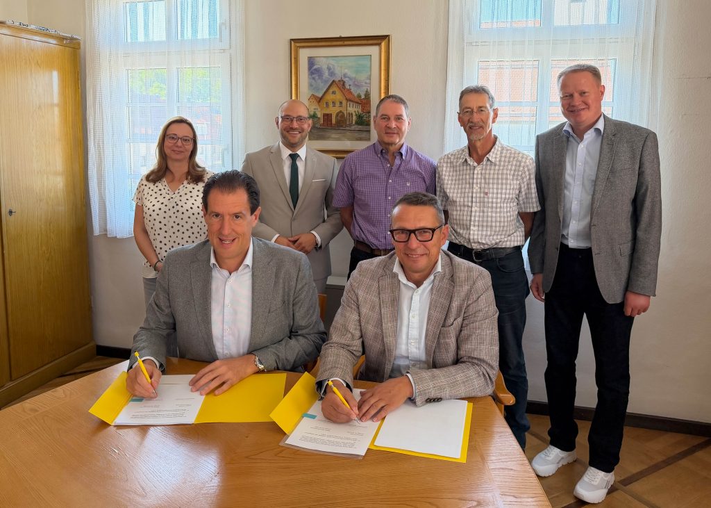Felix Stiegeler und Lenningens Bürgermeister Michael Schlecht unterzeichnen den Zuwendungsvertrag im Beisein des Landrats, der Ortsvorsteher und Vertreter des Zweckverbands und der Gigabit Region Stuttgart.