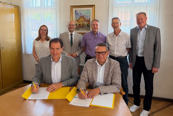 Felix Stiegeler und Lenningens Bürgermeister Michael Schlecht unterzeichnen den Zuwendungsvertrag im Beisein des Landrats, der Ortsvorsteher und Vertreter des Zweckverbands und der Gigabit Region Stuttgart.