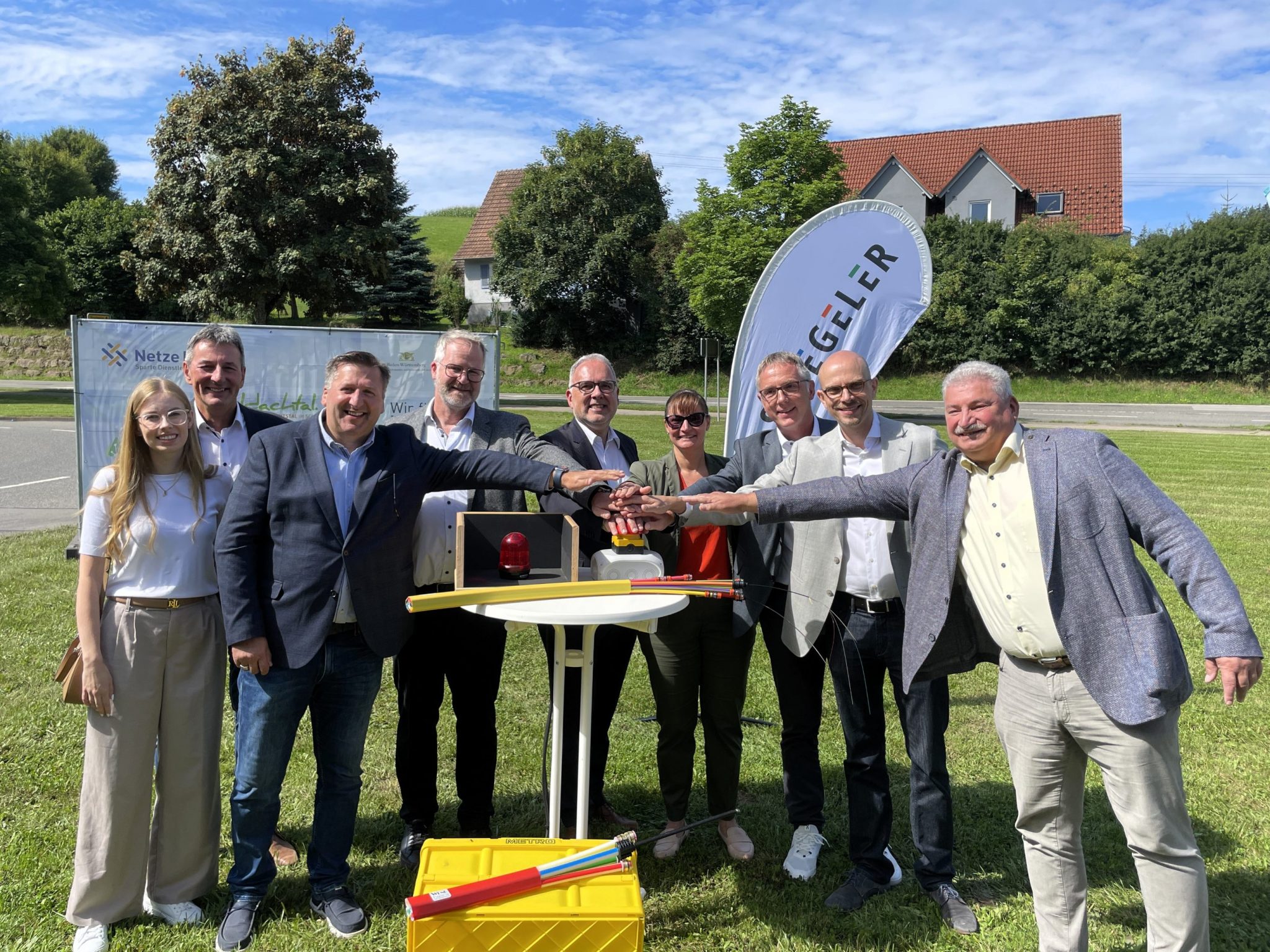Vertreter der Gemeinde, des Landkreises und der am Ausbau beteiligten Firmen drücken zur Inbetriebnahme des Glasfasernetzes in Waldachtal symbolisch auf einen roten Knopf.