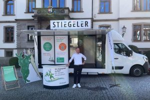 Stiegeler Info-Mobil mit Mitarbeiter vor dem Rathaus in Schönau auf Marktplatz