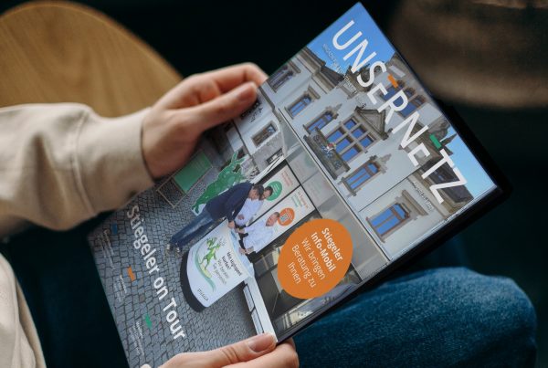 Eine Person hält die neue Ausgabe des Stiegeler Kundenmagazins Unser Netz in den Händen.