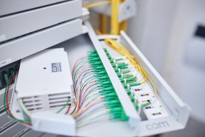 Gelbe Glasfaserkabel in einem Verteiler.