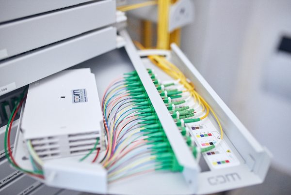 Gelbe Glasfaserkabel in einem Verteiler.